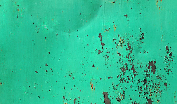 Light-green textured metallic wall, background. Ancient, mangy surface with cracked green paint on rusty background. An old surface with faded green color and paint. Green or viridian painted backdrop