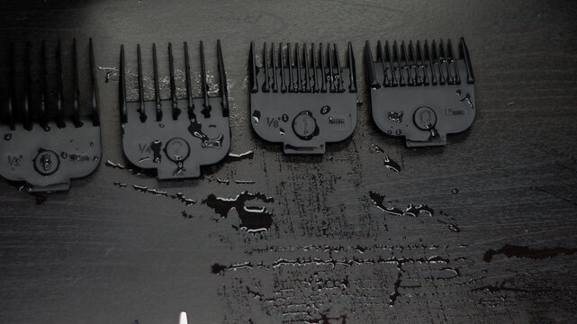 Hair clipper attachments guard combs on a black table background