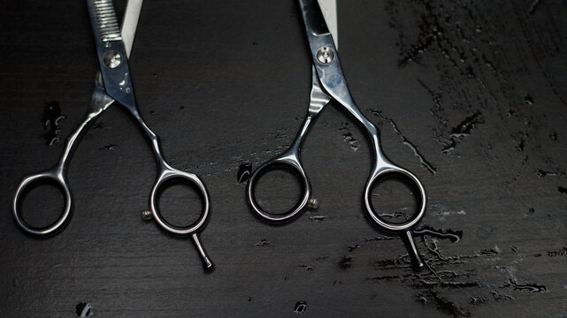 Professional hairdressing scissors on a black table background