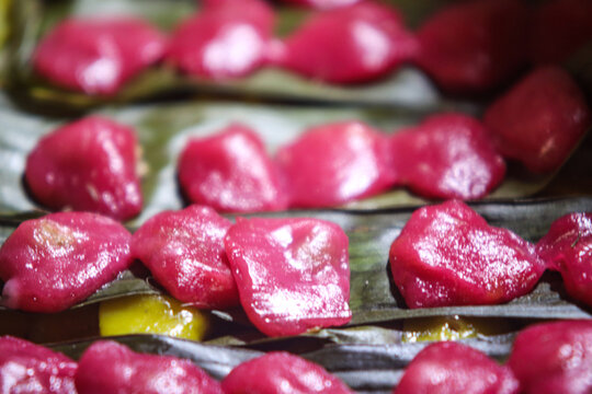 Traditional Pink Kipo Sticky Rice Cakes Lined on Banana Leaf Displayed in Market