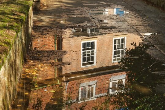 Red brick house reflected in a puddle 