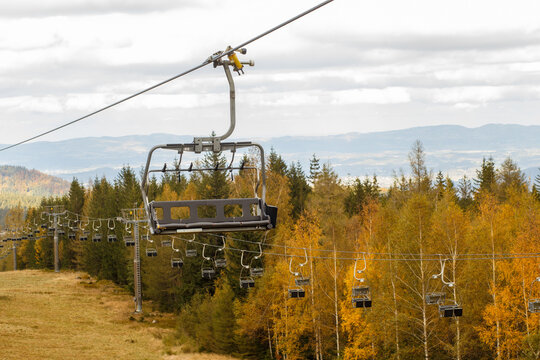 Empty chairlift over autumn mountain forest landscape