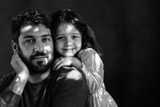 Intimate Black and White Portrait of a Young Father and Daughter Sharing a Tender Bond