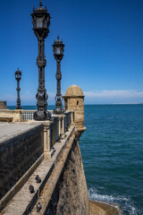 Ornate iron lampposts on historic seaside promenade © Oksana
