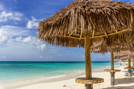 Aruba beach with palapas by turquoise ocean