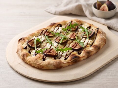 Fresh fig flatbread with arugula and balsamic glaze on a plate