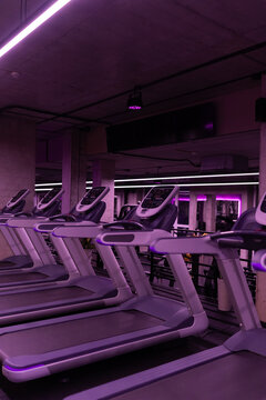 Contemporary fitness center with treadmills and purple atmospheric lighting