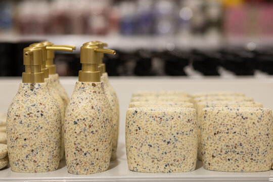 Closeup Of Gold Dispenser Pumps On White Honeycomb Bottles.