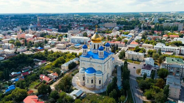 Yelets, Lipetsk region, Russia. Ascension Cathedral, white stone walls and gilded dome rising above blue rooftops, Drone footage over the historic city center. Drone footage, Departure of the camera