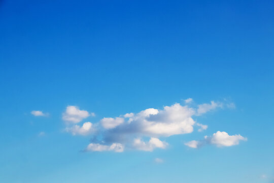 Clear blue sky with small clouds at bottom of image