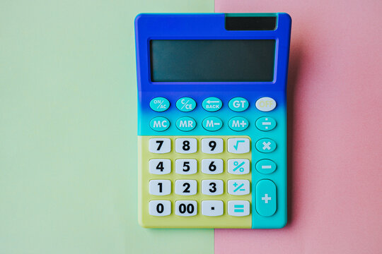 Colorful plastic calculator with large buttons and display on a pastel background, featuring blue, green, and yellow sections for easy visibility and use