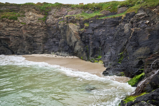 The sea and rocks at Praia das Catedrais, Beach of the Cathedrals in Ribadeo, Galicia Spain cloudy sky