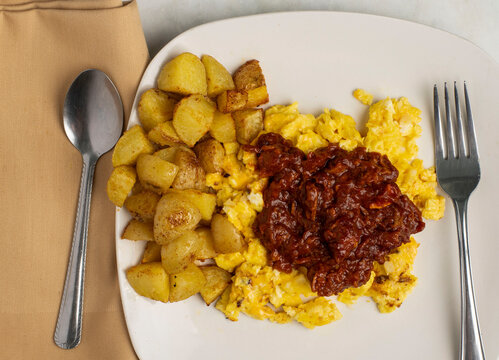scramble eggs top with pulled pork  with home fries