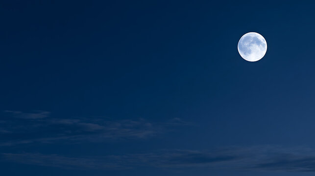 Bright full moon glow in dark blue night sky with subtle clouds, celestial body in outer space, astronomy background for nature theme