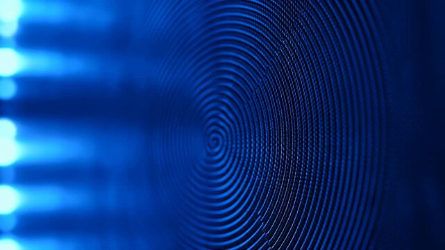 Blue illuminated speaker cone vibrates in close-up as concentric ridges ripple around the center, with soft cyan light bars glowing along the blurred left side of frame
