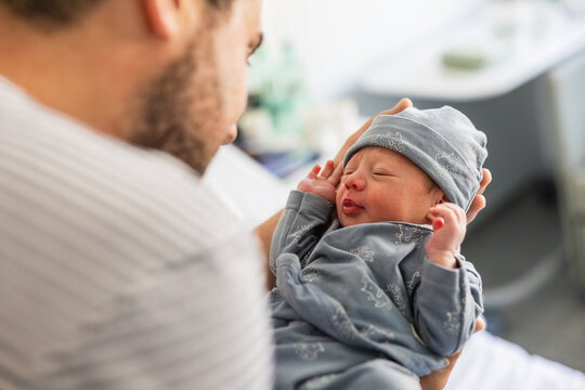 Father holding newborn baby boy creating bond