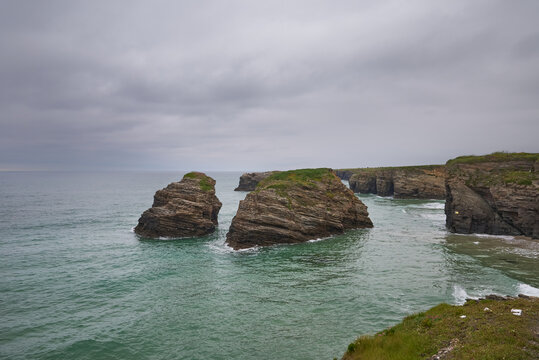 The sea and rocks at Praia das Catedrais, Beach of the Cathedrals in Ribadeo, Galicia Spain cloudy sky