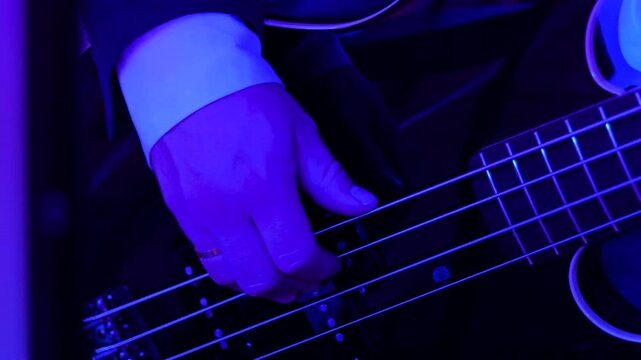 Guitarist plays the guitar. A musician in a musical group on stage gives concert