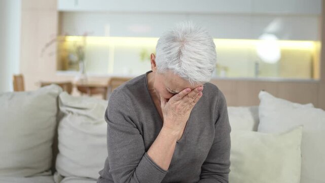 Sad tired ill sick lonely disappointed older senior woman sitting at home alone. Unhappy mature grandmother experiencing grief relative death bad news. Stressed elder lady suffering from loneliness