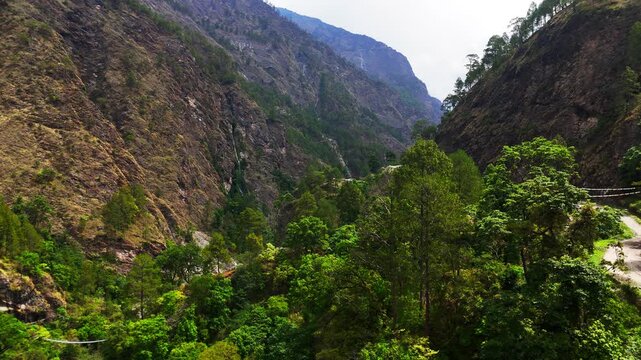 Rasuwagadhi, Nepal - 29 August 2026: Aerial view of the Trishuli River valley featuring steep mountain slopes, lush green forests, and a winding road.