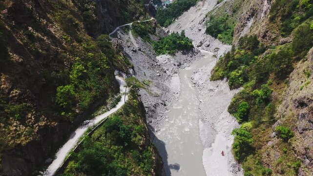 Rasuwagadhi, Nepal - 29 August 2026: Aerial view of the Trishuli River flowing through a deep mountain valley with a winding road along the steep rocky slopes.