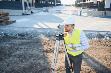 Fototapeta premium Surveyor geodetic engineering worker measuring land on construction site