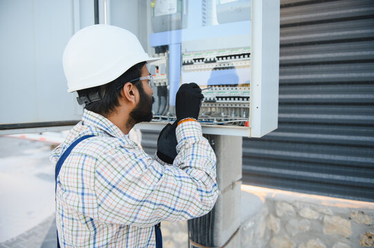 Indian electrician working on electrical fuse box