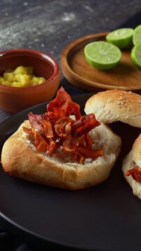 Hand preparing traditional Mexican street food cemita al pastor with marinated pork
