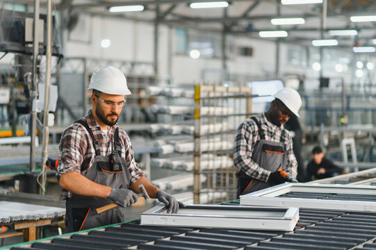 Workers manufacturing plastic pvc window frames in modern factory