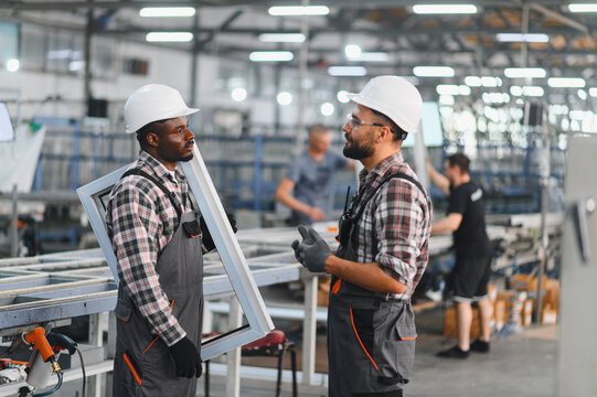 Factory workers discussing manufacturing pvc window frames