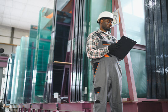 African american worker checking production in glass factory