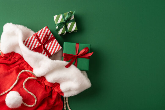 Merry Christmas Santa Claus present sack with wrapped gifts and Happy New Year festive decor on green background