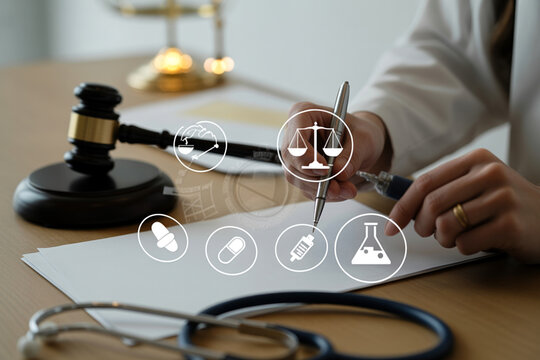 Medical malpractice concept with judge gavel and doctor writing on medical report on office desk.