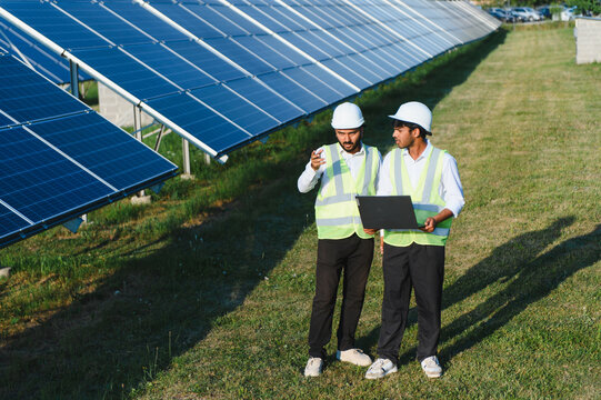 Indian engineers monitoring solar panels on an energy farm