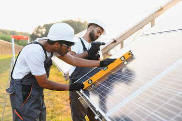Fototapeta premium Indian engineers installing solar panels for renewable energy