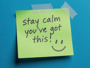 Naklejka premium A green sticky note with the words stay calm youve got this and a face is taped to a blue textured background. The message encourages persistence and positivity when facing challenges.