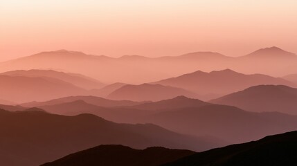 Obraz premium Warm dusk light covers a blurred horizon with layers of distant hills and mountains. The scene invites quiet reflection and a moment of pause.