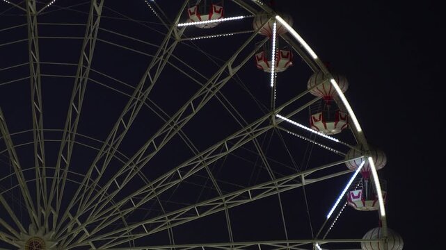 Close Up of Ferris Wheel Structure and Gondolas at Night