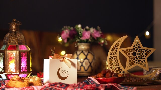 A close-up of a gift box and assorted sweets on an Eid celebration table