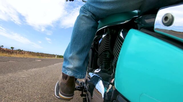 POV from the passenger footrest as a biker rides a custom motorcycle from a roadside pull off onto a rural road, with natural engine and road sounds.