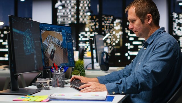 Male specialist uses artificial intelligence and neural networks to design an apartment floor plan, working with computer-aided layout tools and architectural software for interior design planning.