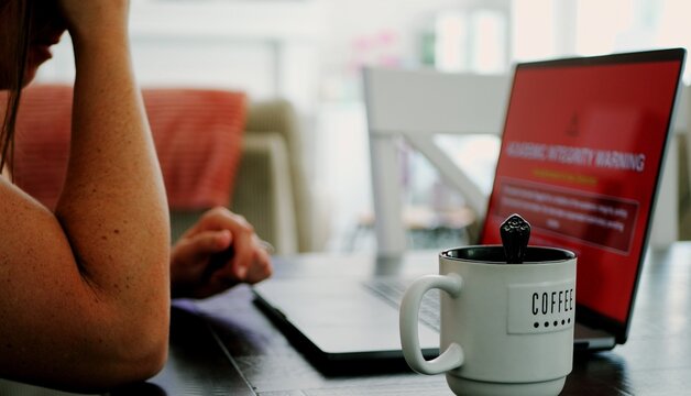 Adult college student uses artificial intelligence AI chat bot to write assignment breaking academic fair use policy cheating educational assignment