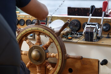 Poste de pilotage de bateau avec barre en bois et instruments © Bovek Photography