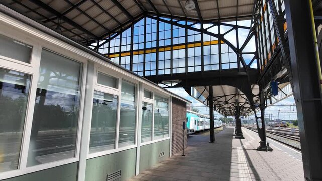 Covered platform at Hengelo railway station in the Netherlands with steel roof structures, glass windows, and tracks leading outside.Hengelo, Netherlands 29.07.2026