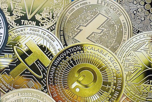 KYIV, UKRAINE - 22 AUG 2026 Fictional crypto currency coins emblems stickers on table