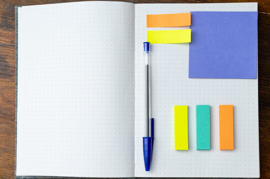 Creative Workspace with Notebook Pen and Sticky Notes. Blank Notebook and Colorful Notes for Organization
