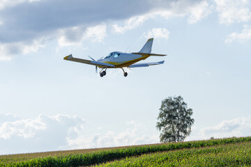 Light aircraft flying over a green field   Lekki samolot lecący nad zielonym polem © Adrian White
