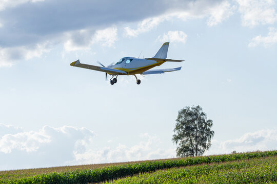 Light aircraft flying over a green field | Lekki samolot lecący nad zielonym polem