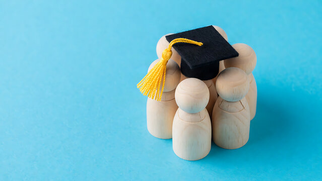 Cute foam hand figures celebrating graduation with mortarboard cap on blue background