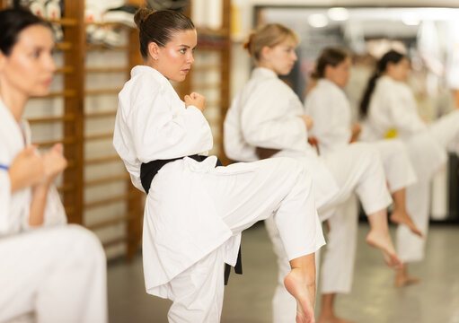 Kata karate teacher conducts classes and performs movements and fighting techniques together with followers. Girls train and practice kata during training seminar. .......